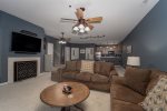 LOWER LEVEL LIVING ROOM AREA WITH A TV, FIREPLACE, COUCHES, POOL TABLE, MINI KITCHEN, LAUNDRY ROOM, UTILITY ROOM, BATHROOM 3 & BEDROOM 4 SUITE